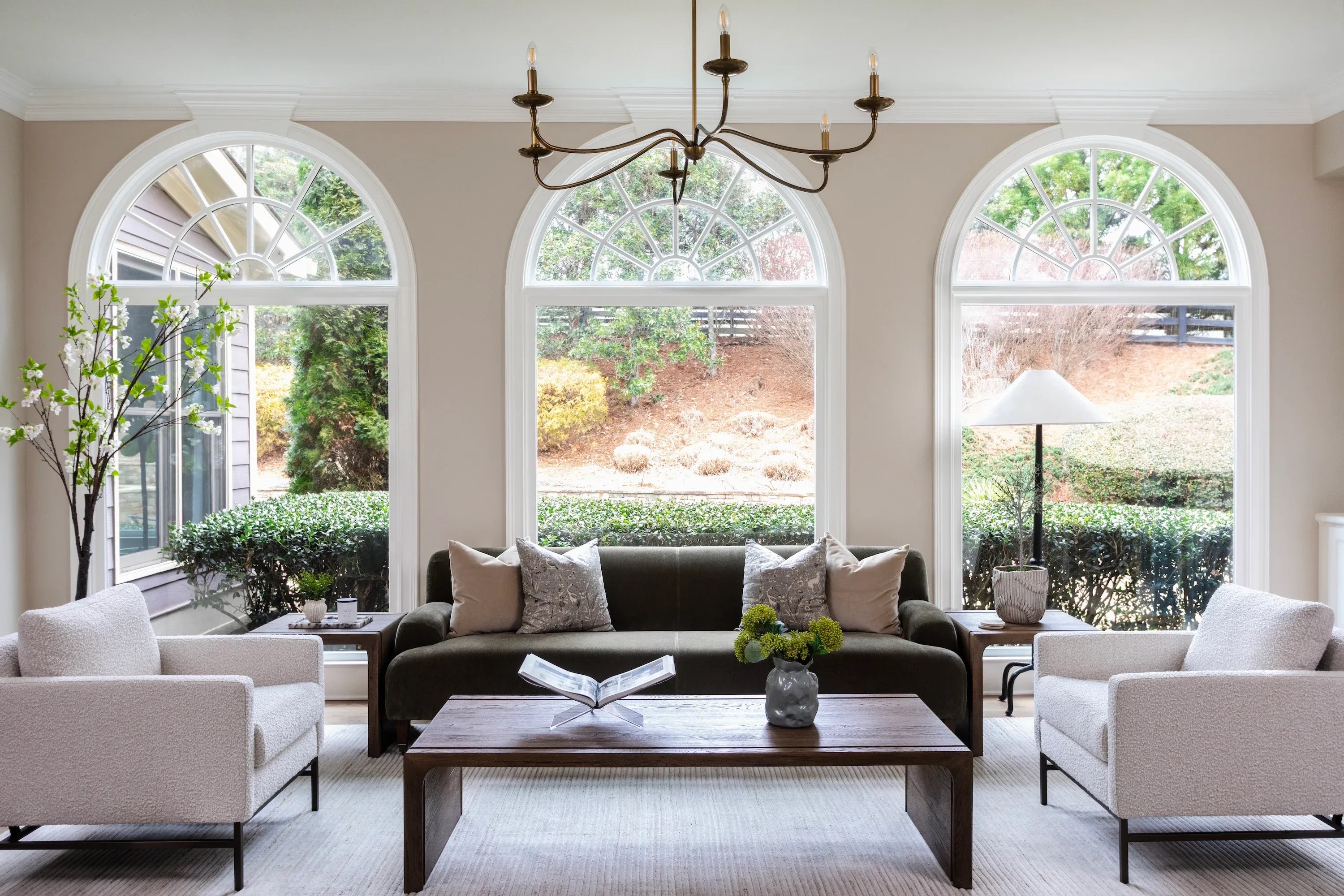 Traditional living room with arched windows, classic architectural details, and a mix of modern and traditional furnishings.